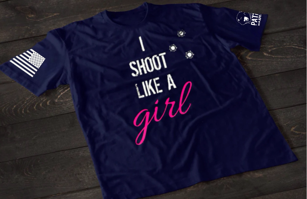Navy Blue women’s I Shoot Like a Girl T-shirt featuring bold white text with pink script lettering and bullet hole graphic accents